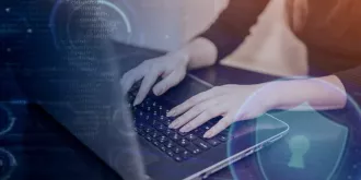 Osoba korzysta z laptopa, pisząc kod związany z technologią deepfake. | © Name