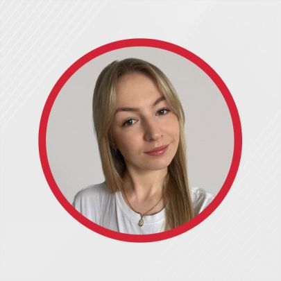 Kobieta z długimi blond włosami ubrana w biały t-shirt i naszyjnik, otoczona czerwonym kołem.