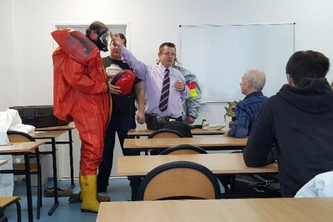 Wykładowca omawia sprzęt ochronny na zajęciach z broni masowego rażenia.jpg