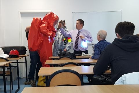 Zakładanie czerwonego kombinezonu ochronnego na ćwiczeniach.jpg