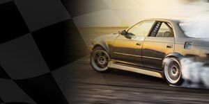 Samochód wyścigowy driftuje na torze, w tle widać flagę szachową, symbolizującą motorsport.